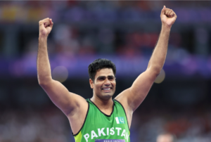 Arshad Nadeem a man in a green tank top with his arms up 